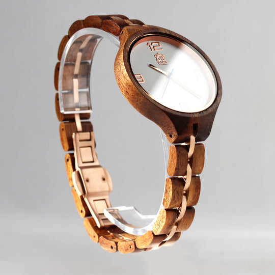 sun reflecting slightly off face of solid koa watch