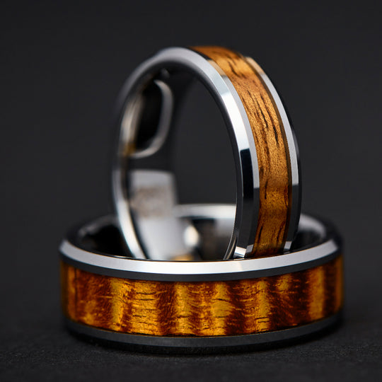 tungsten flat face koa wood inlay rings nestled together to display the top ring