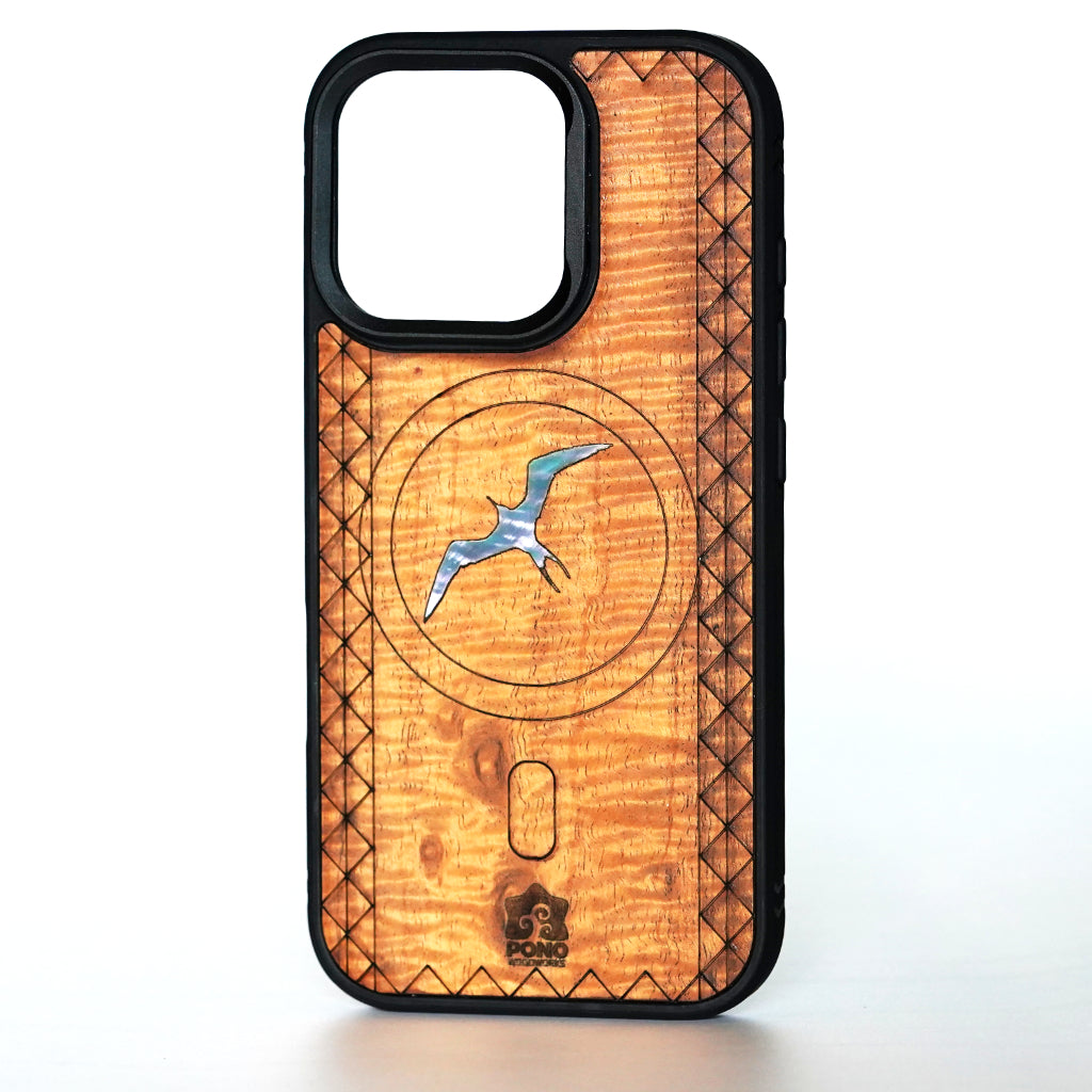 A wooden phone case with a black bumper frame, featuring a natural KOA wood grain backplate with a central circular MagSafe design inlaid with a blue and white iwa bird, and a small Pono logo at the bottom.