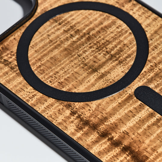 closeup of curly koa wood grain and magnet inlay on phone case