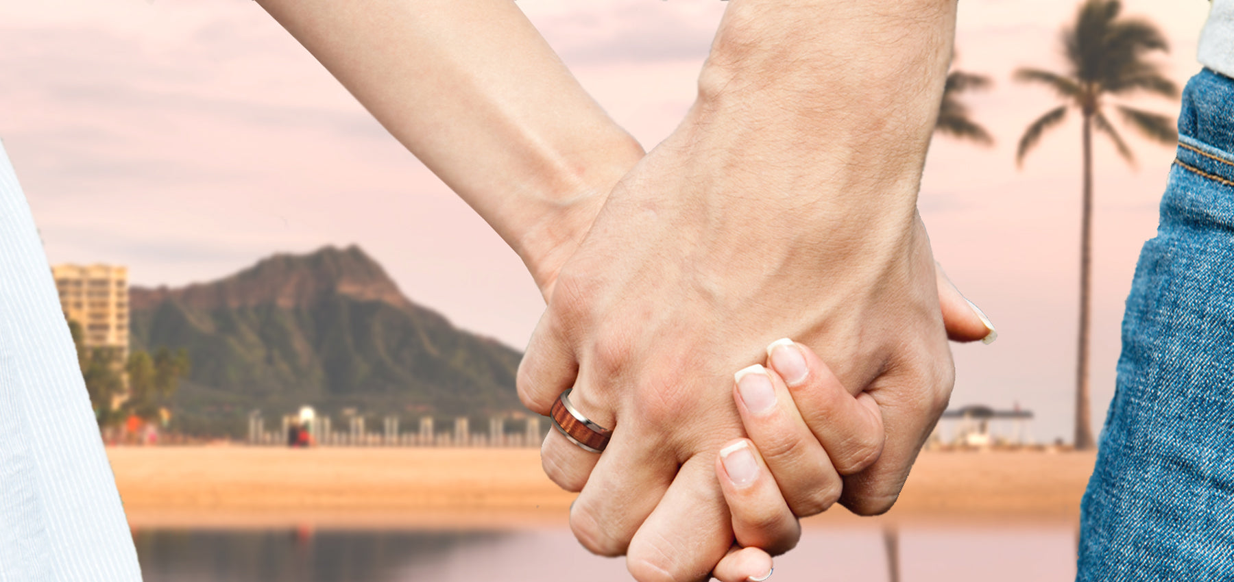 couple holding hands showing koa wood ring and diamond head in the background