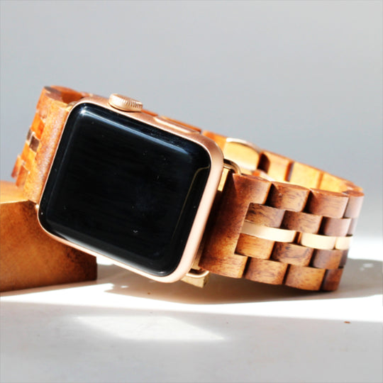 solid koa wood band with metal stringer attached to a iwatch