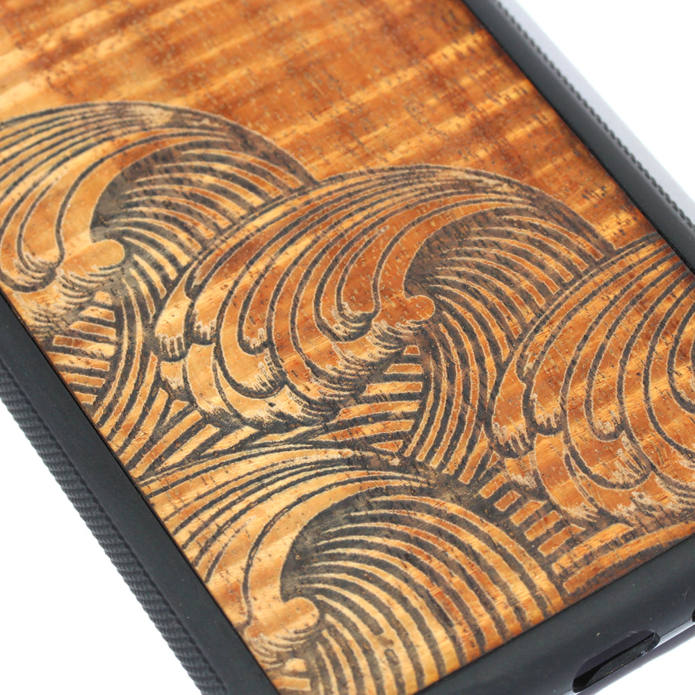 closeup of laser etched wave design on koa wood